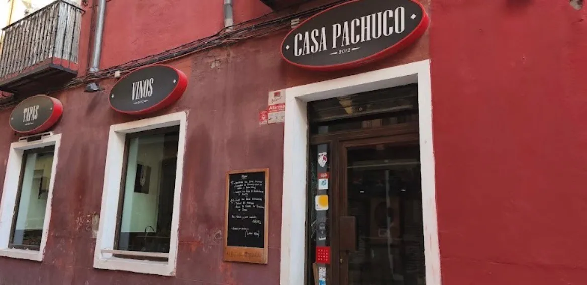 Fachada roja con el rótulo de Casa Pachuco y la pizarra junto a la puerta